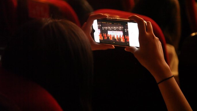 剧场里观众手机拍摄舞台