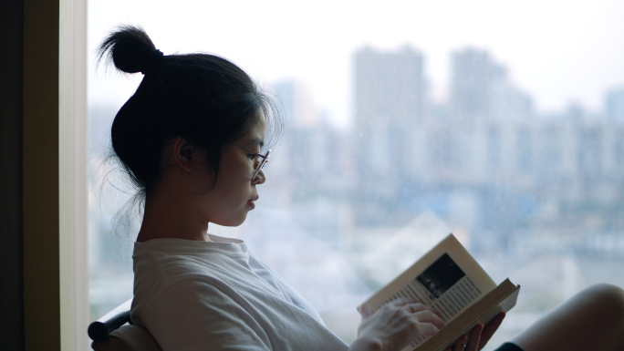 女孩在落地窗前看书4k视频素材