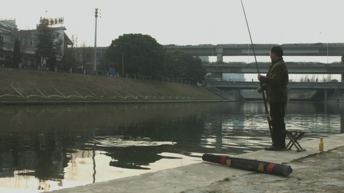 男子在城市河里钓鱼