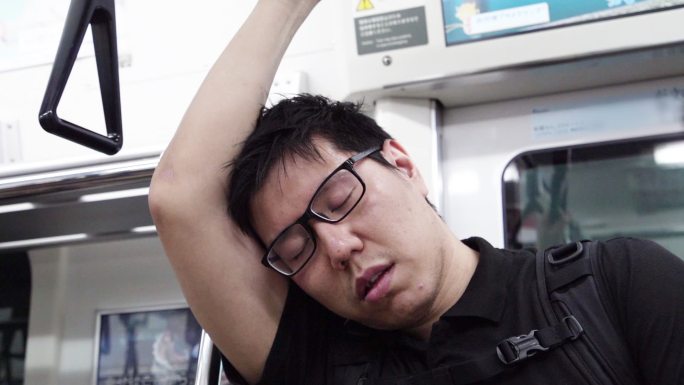 累了的家伙站在地铁上睡觉。