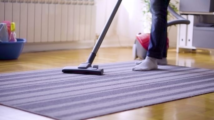 女士在家用吸尘器清洁地毯