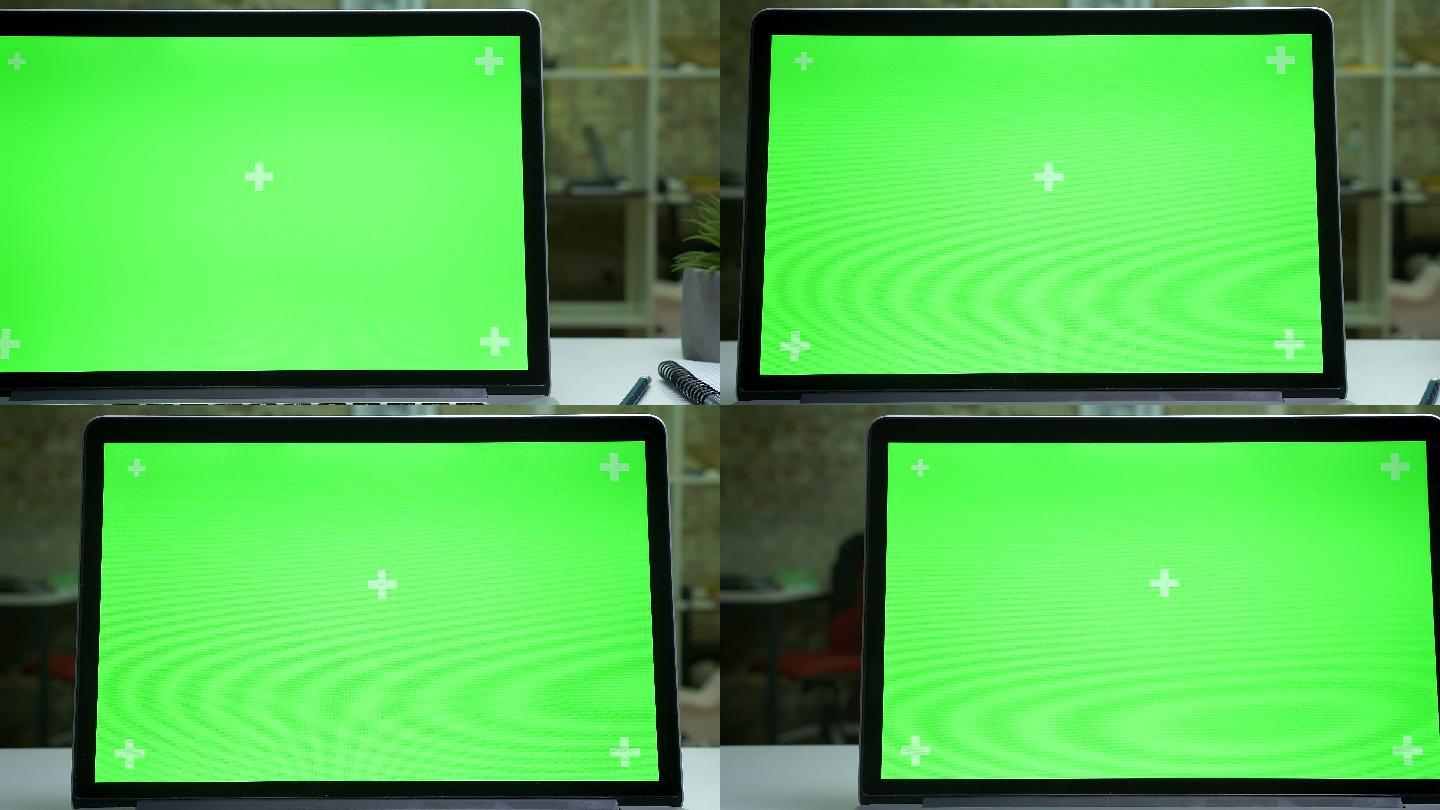 现代办公室中笔记本电脑的绿色屏幕