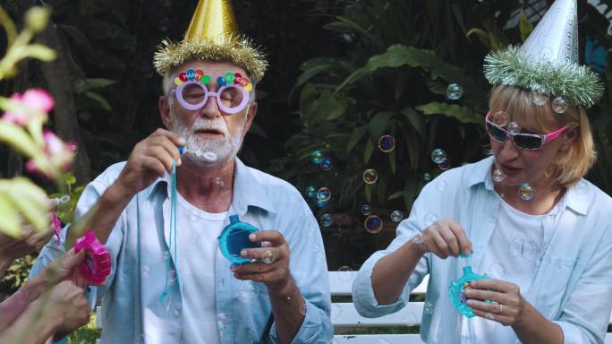退休社区：在生日派对上戴派对帽的活跃老年人