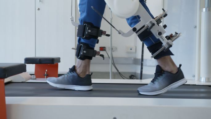 男子在医院借助外骨骼机器人进行物理治疗