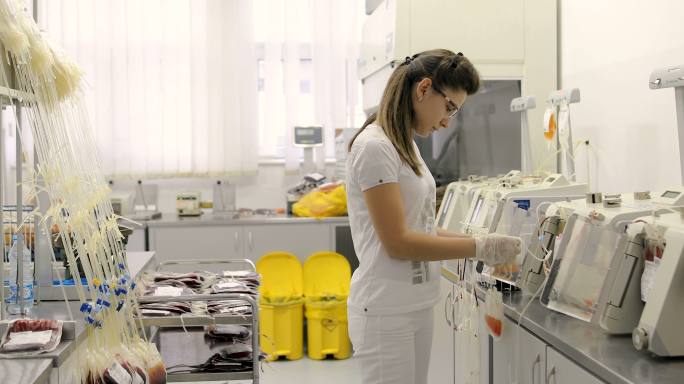 在实验室从事血液和血浆过滤工作的年轻护士