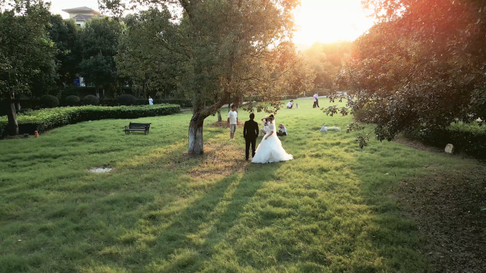 4K夕阳时分拍摄婚纱照的情侣航拍空镜