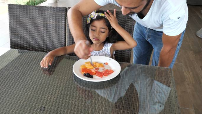 拉丁裔父亲喂养他四岁的女儿