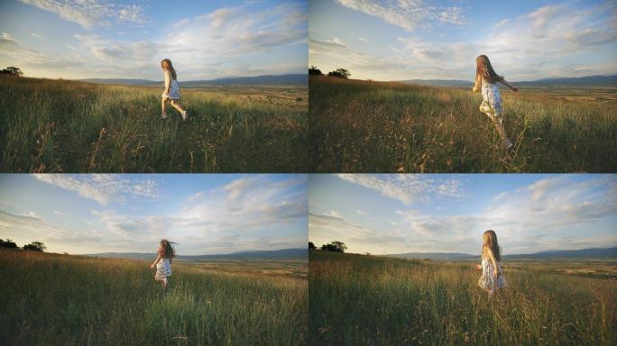 女孩在草地上的日落中奔跑