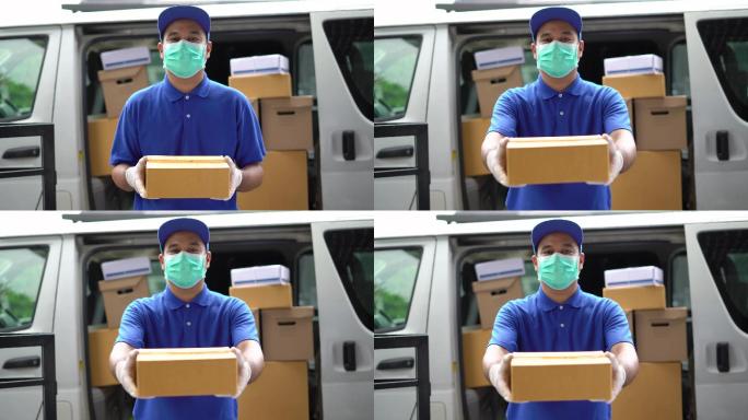 男子带防护面罩拿着包裹纸箱站在货车前面。