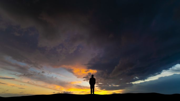 云流背景下的人影夕阳延时商务成功人士矗立