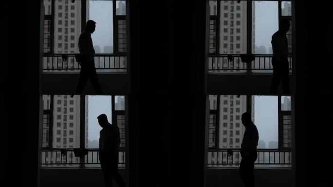 【原创】窗前徘徊踱步思考问题的男人剪影