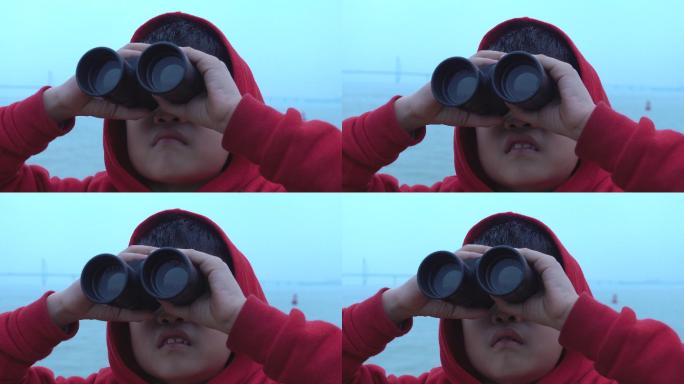 小男孩在游船上用双筒望远镜观看时感到惊讶