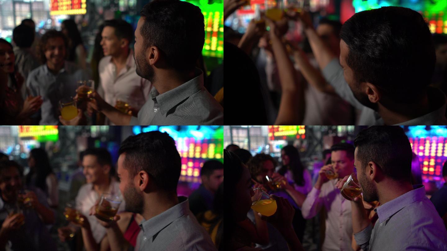 帅哥在酒吧里和朋友们一起喝酒、跳舞、祝酒