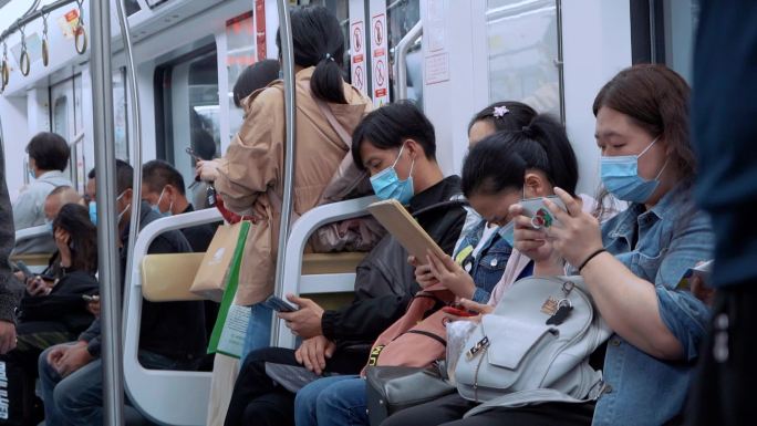 地铁上站台候车低头玩手机看手机的上班族