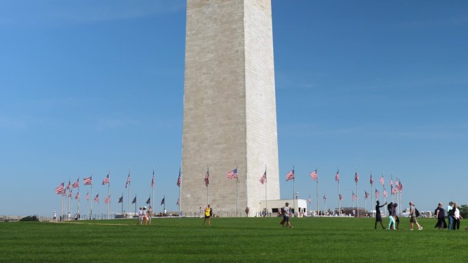 参观华盛顿纪念碑基地的游客的全景照片