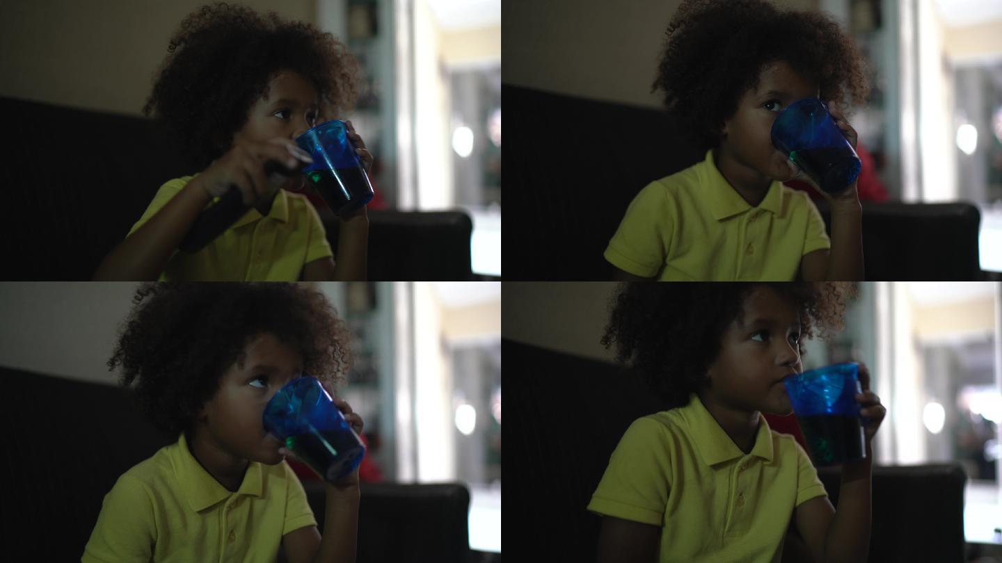 小男孩在客厅看电视喝着水