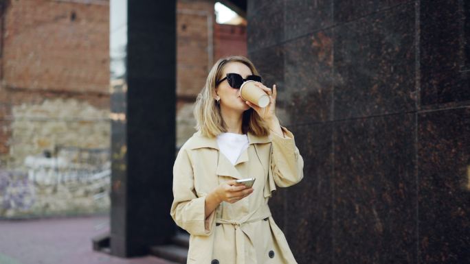 边喝咖啡边使用手机的女人