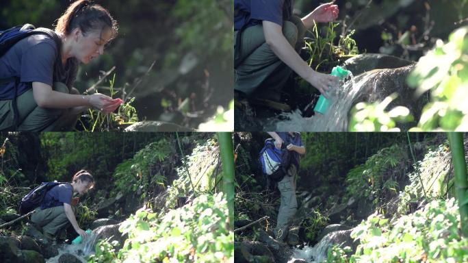 背包客美女山间小溪双手捧水喝山泉水