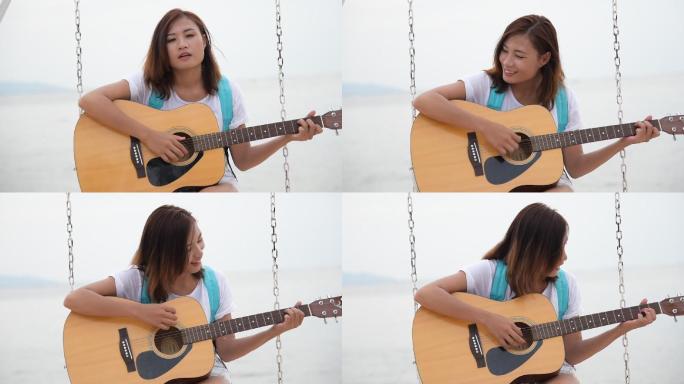 美丽的女孩在海滩上弹原声吉他。