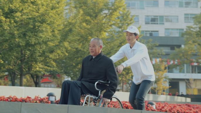 年轻志愿者帮助老年人推轮椅