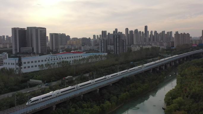 城市两辆动车组交叉经过夕阳驶过铁轨和谐号