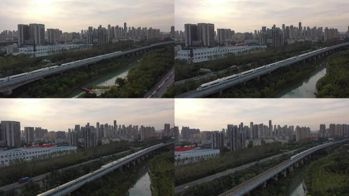 城市两辆动车组交叉经过夕阳驶过铁轨和谐号