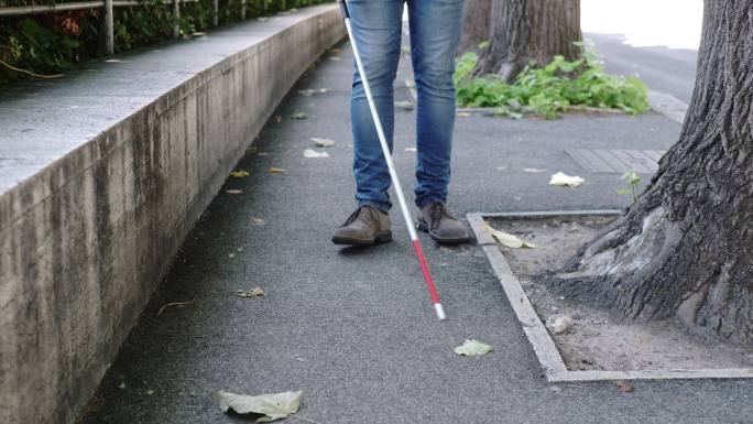 盲人拄着拐杖在街上行走