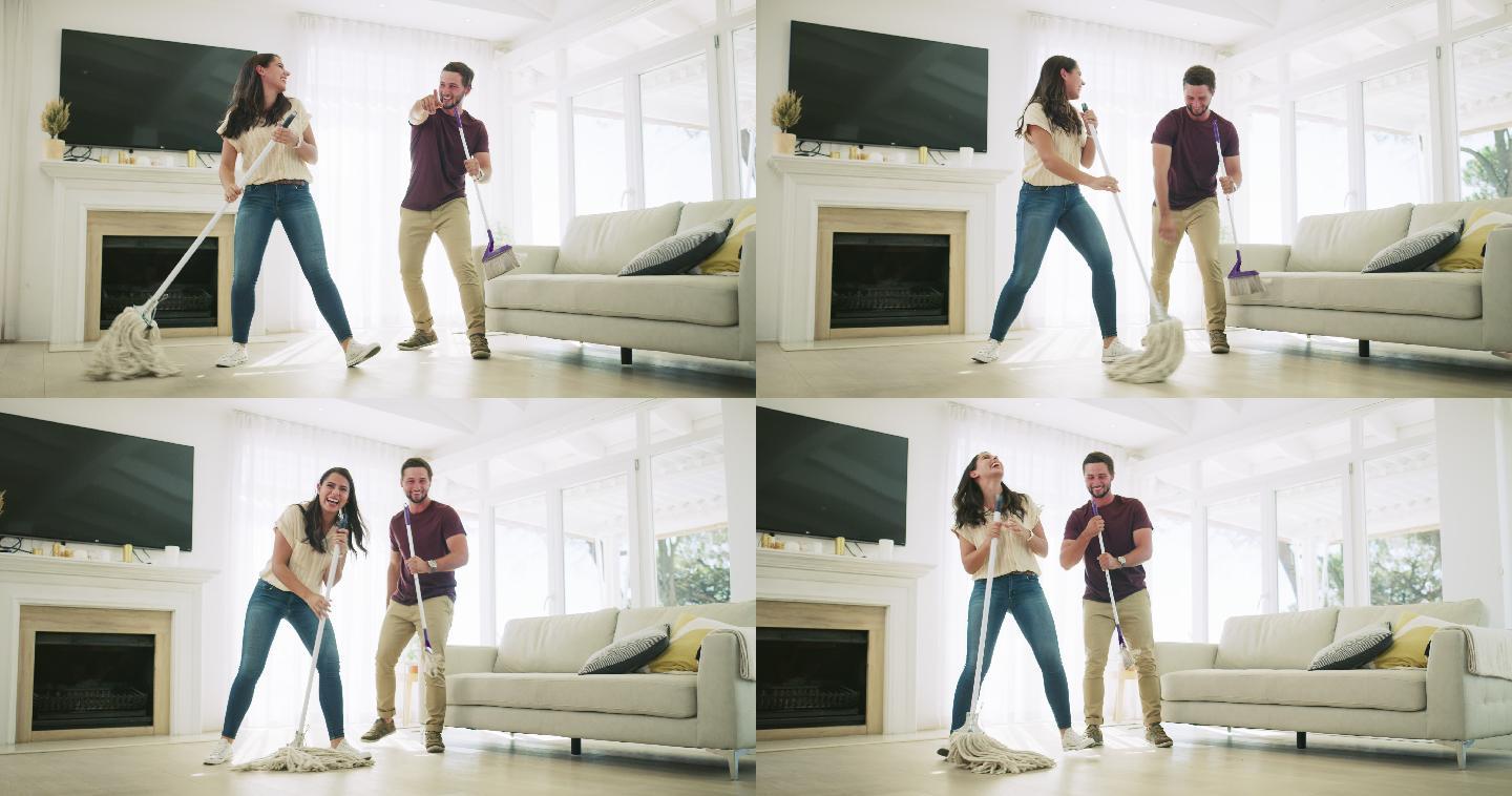 一对年轻夫妇在家打扫客厅时唱歌跳舞