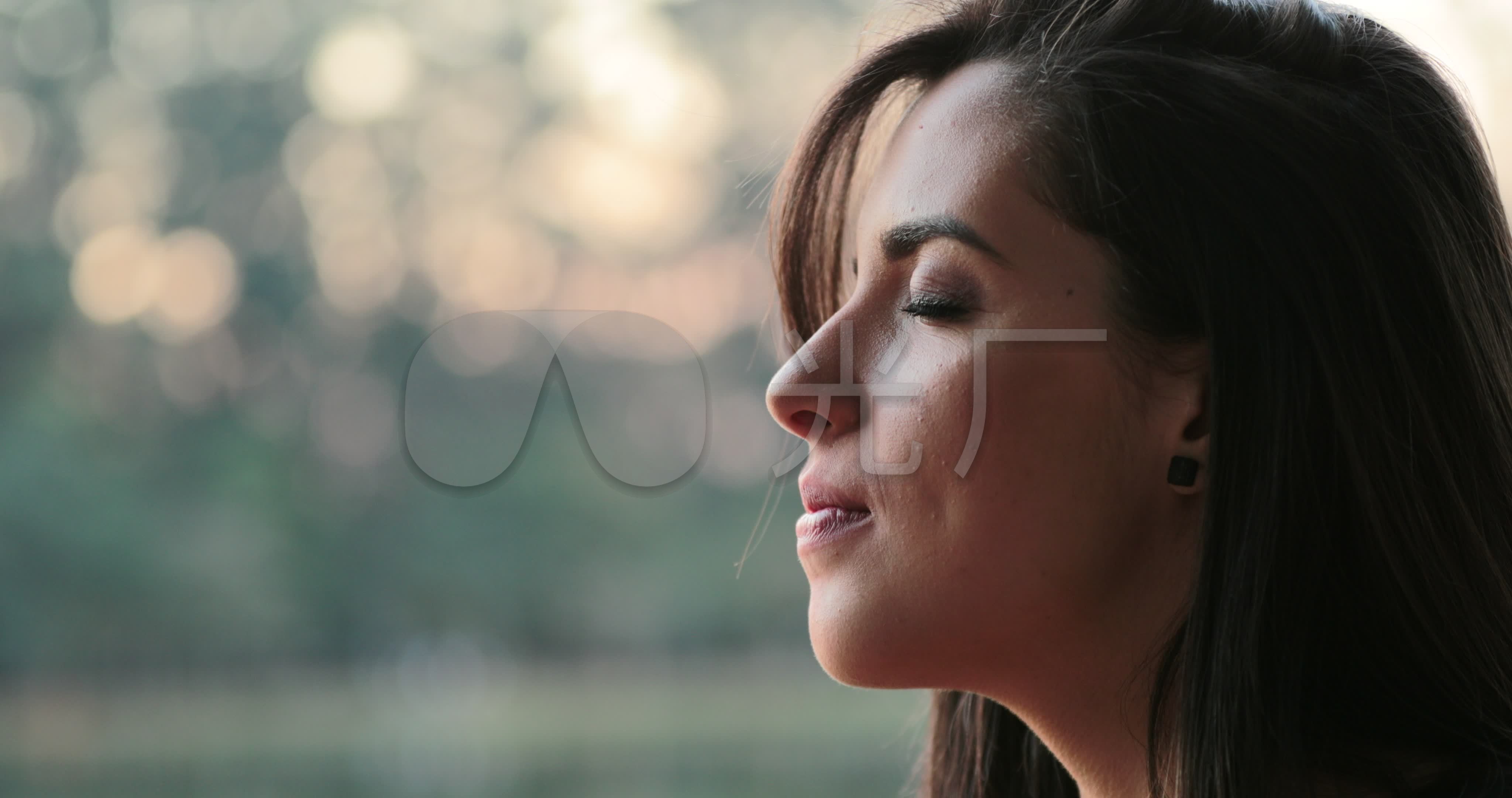 在公园外面闭着眼睛深呼吸的年轻女子