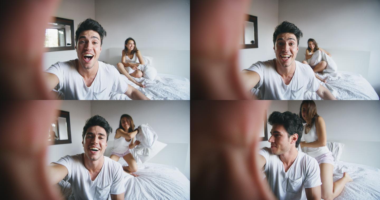 新婚夫妇在卧室里用智能手机跟亲朋好友视频