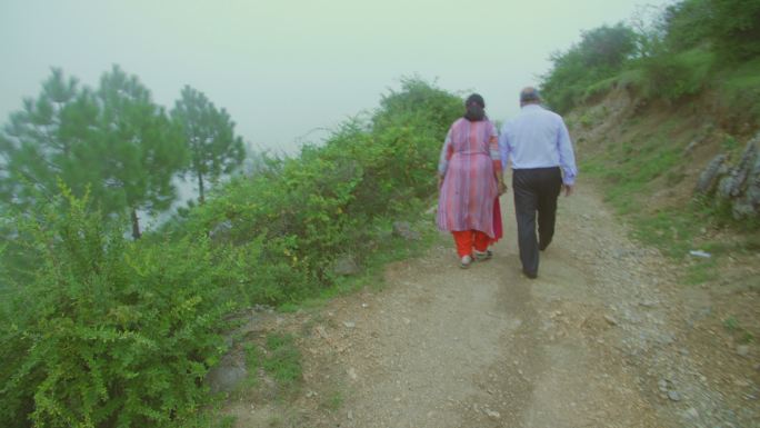 这对退休的老夫妇在雾天牵着手散步。