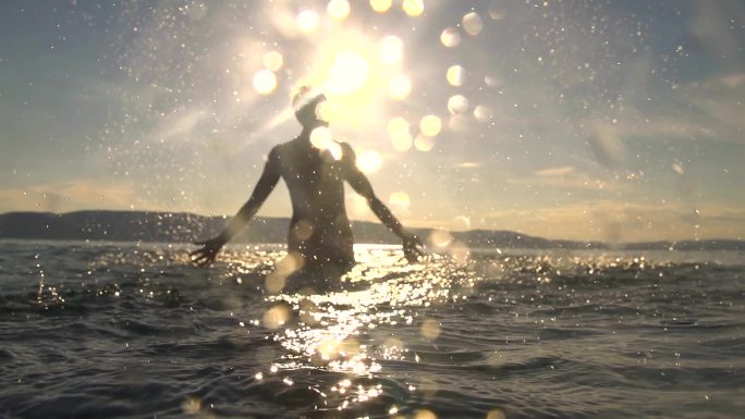 一名年轻女子站在浅海中向自己泼水