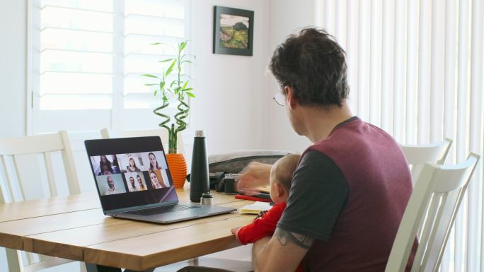 一位在家参加在线网络会议的在职父亲。