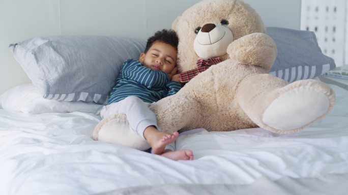 小男孩抱着泰迪熊玩偶睡觉