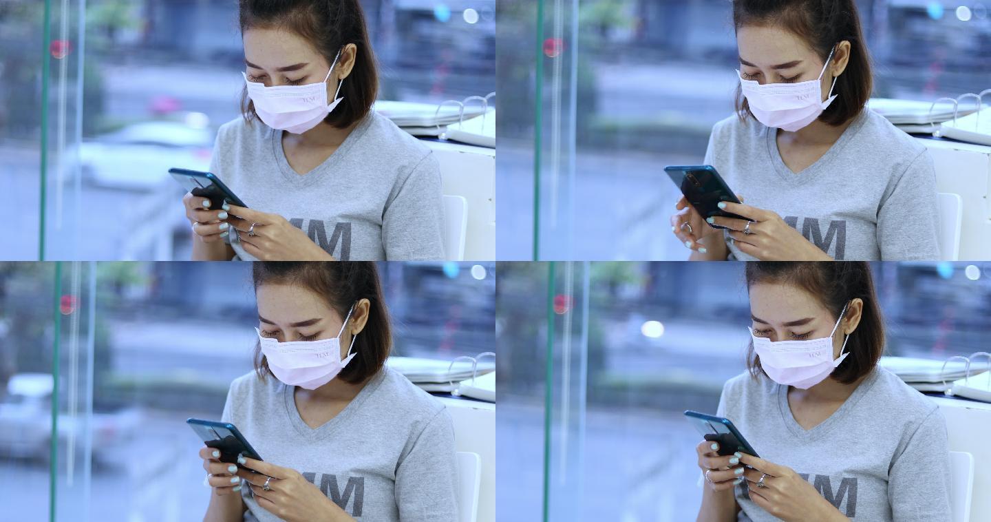 年轻女子使用手机时戴着口罩