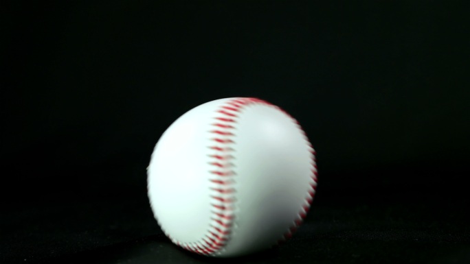 黑色背景上滚动的棒球