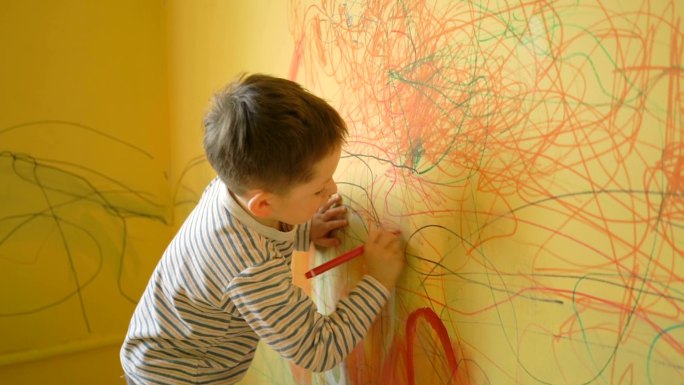 男孩在家里的墙上画画