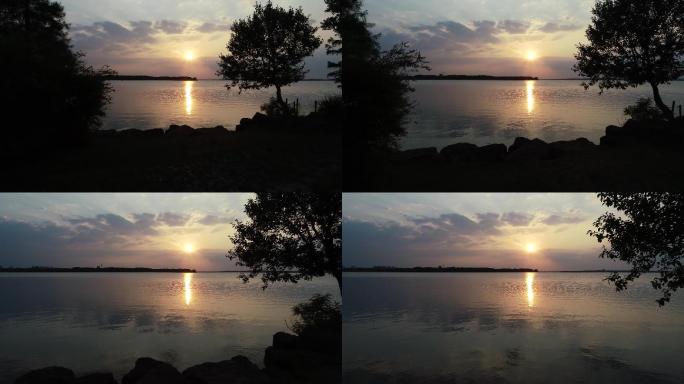 湖边夕阳落日余晖在树梢闪耀