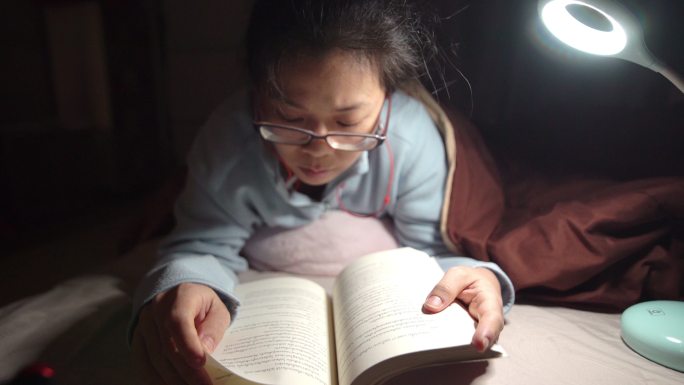 女生晚上在床上看书