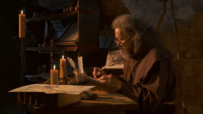 中世纪抄写员在烛光下书写