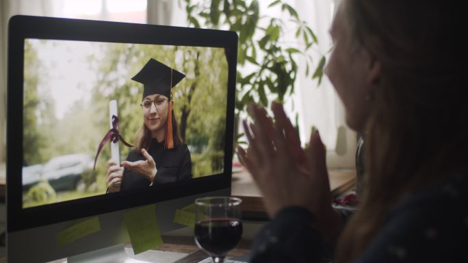 一名女子在家通过视频电话庆祝青少年毕业