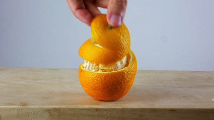 手在木制砧板上很容易剥橘子皮。
