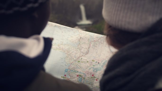 夫妇用地图和指南针计划旅行