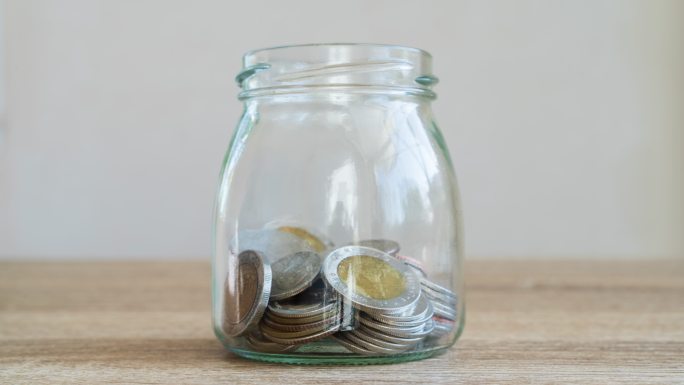 货币储蓄概念将硬币放在玻璃瓶中