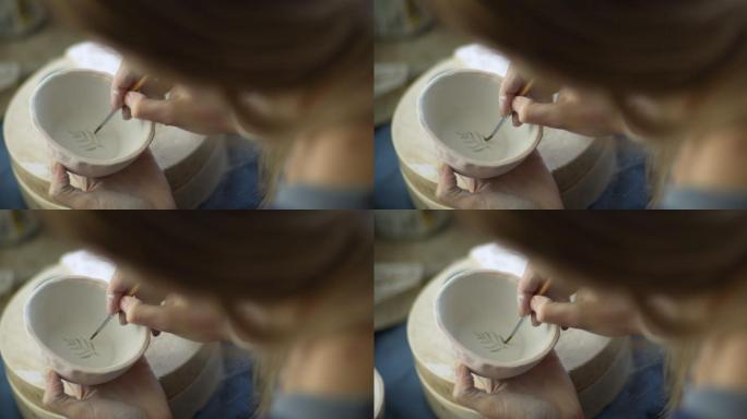 年轻女子在她的陶艺工作室制作手工陶瓷
