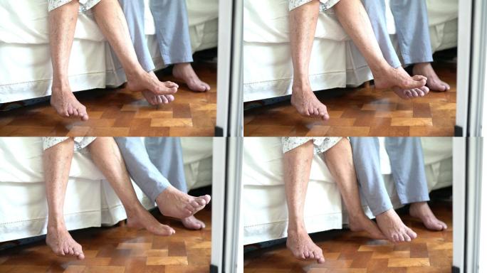 一对老年夫妇的脚放在床边的低角度视图