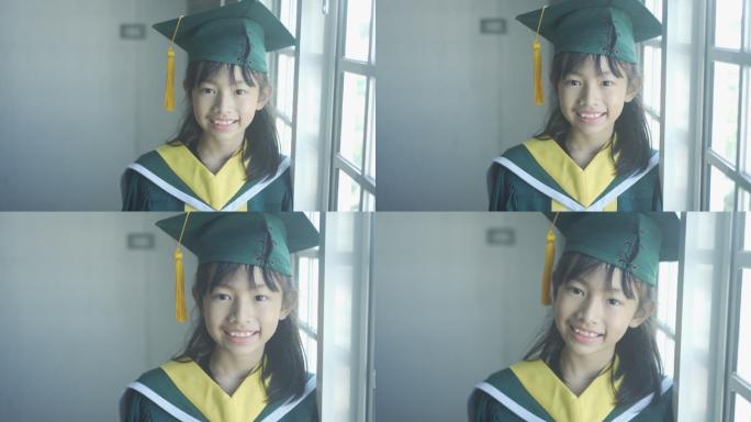 戴着毕业帽和长袍的亚洲小学生