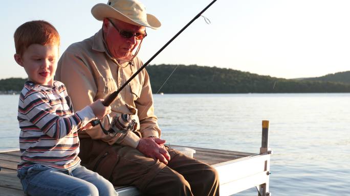 祖父和孙子在日落时钓鱼