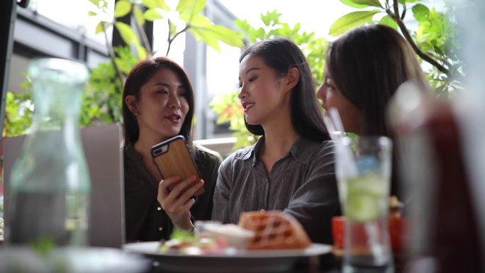 在咖啡馆使用智能手机的女性朋友