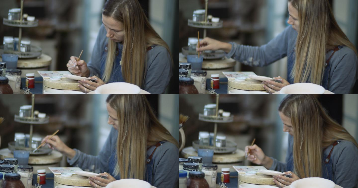 年轻女子在她的陶艺作坊里画陶瓷